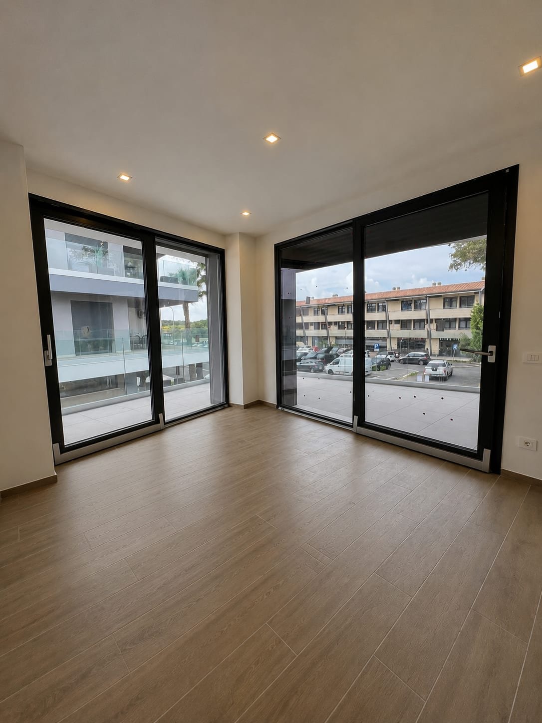 Interno con grandi vetrate scorrevoli e pavimento in parquet